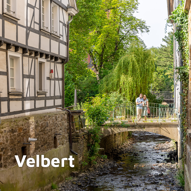 Paar steht auf einer Brücke in Velbert-Langenberg und schaut auf ein Handy.