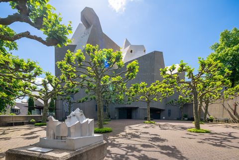 Der Mariendom in Velbert. Davor sieht man eine Skulptur als kleine Version des Gebäudes im Hintergrund.