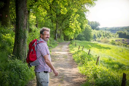 Manuel Andrack hikes along the edge of a forest on the neanderland STEIG