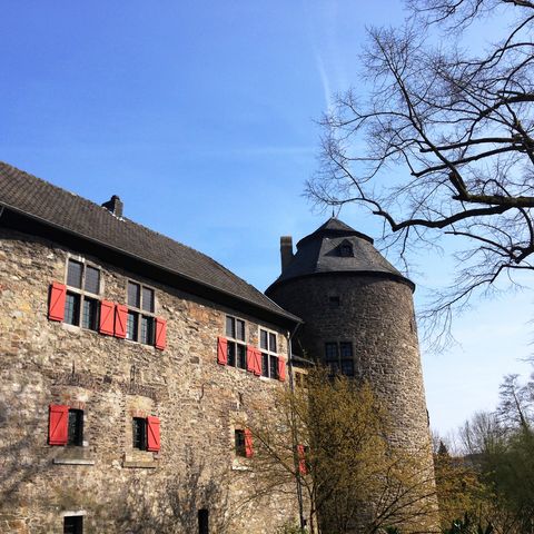 Vista laterale del castello con fossato Haus zum Haus a Ratingen con edificio e torre