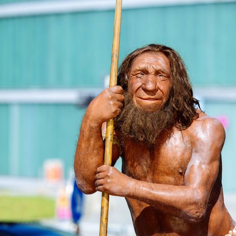 Фигура неандертальца стоит снаружи перед зданием Музея неандертальцев в Меттманне.