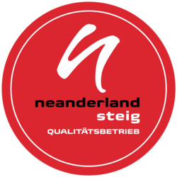 Die Grafik zeigt das runde und rote Logo des neanderland STEIG Qualitätsnetzwerks