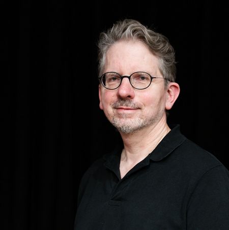 Portraitbild von Matthias Burzinski vor schwarzem Hintergrund