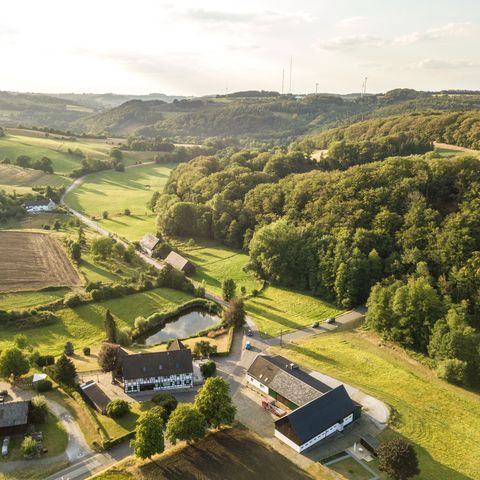 Widok z lotu ptaka na farmy między polami i łąkami w dolinie Windrath w Elfringhauser Schweiz koło Velbert