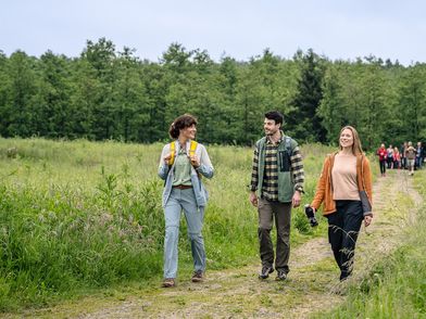 Zwei Frauen und ein Mann wandern auf dem neanderland STEIG