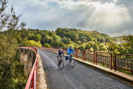 Dos ciclistas en el viaducto Ruhrtalstrasse en Heiligenhaus en la ruta ciclista panorámica Niederbergbahn