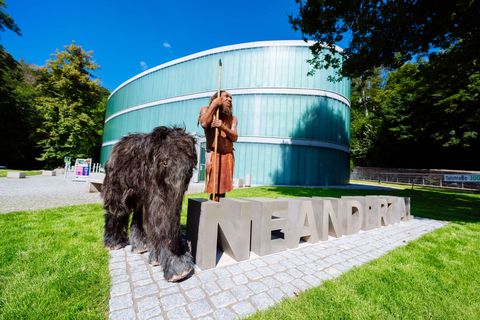Neanderthal figure "Mr N" with mammoth baby Tinka with Neandertal lettering in front of the Neanderthal Museum in Mettmann
