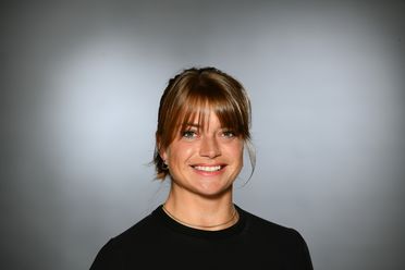 Portrait von Tina Schmidt mit grauem Hintergrund