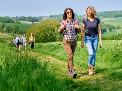 Twee vrienden wandelen op een veldpad tijdens de openingswandeling van de neanderland HIKING WEEK 2022