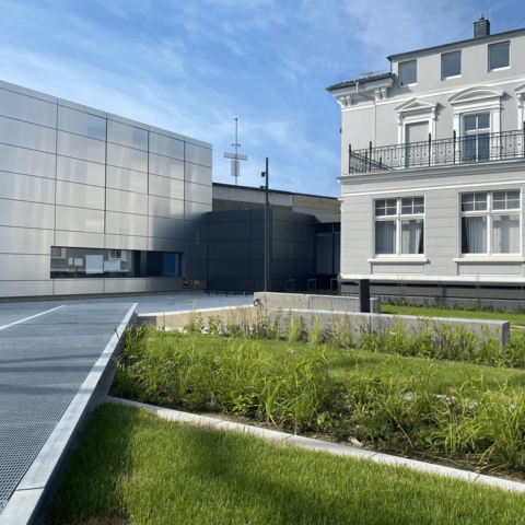Außenanlage mit einem silbernen und einem grauen Gebäude des Deutschen Schloss- und Beschlägemuseums in Velbert