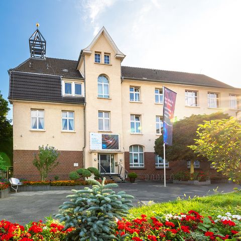Вид на дом Freiherr vom Stein в Лангенфельде с цветами на переднем плане
