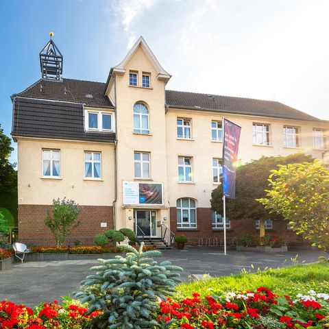 Ansicht Freiherr-vom-Stein-Haus in Langenfeld mit Blumen im Vordergrund