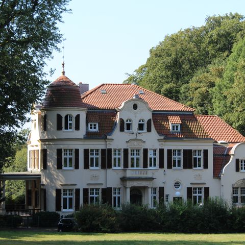 Das Gebäude der Bayervilla umgeben von Wald und Garten in Erkrath